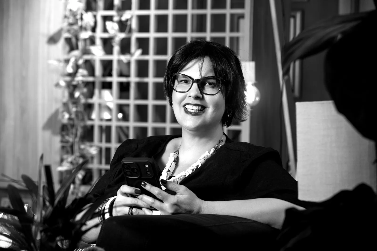Dani Ramos sorrindo, em conversa, sentada em um lounge